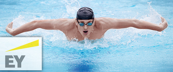 Swimmer in cap and goggles breathing performing the butterfly stroke